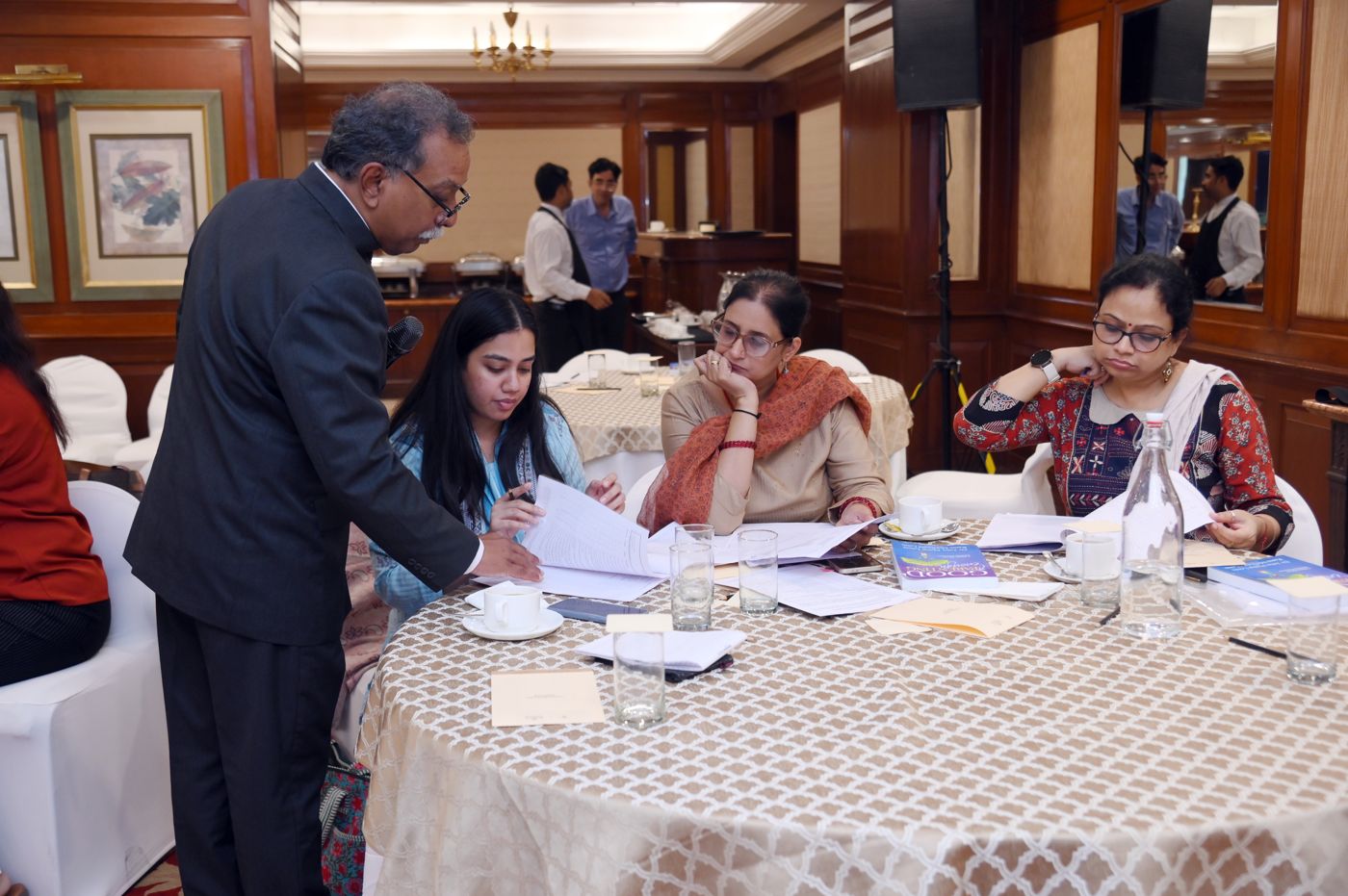 Dr. Louis reviewing work with participants at their table